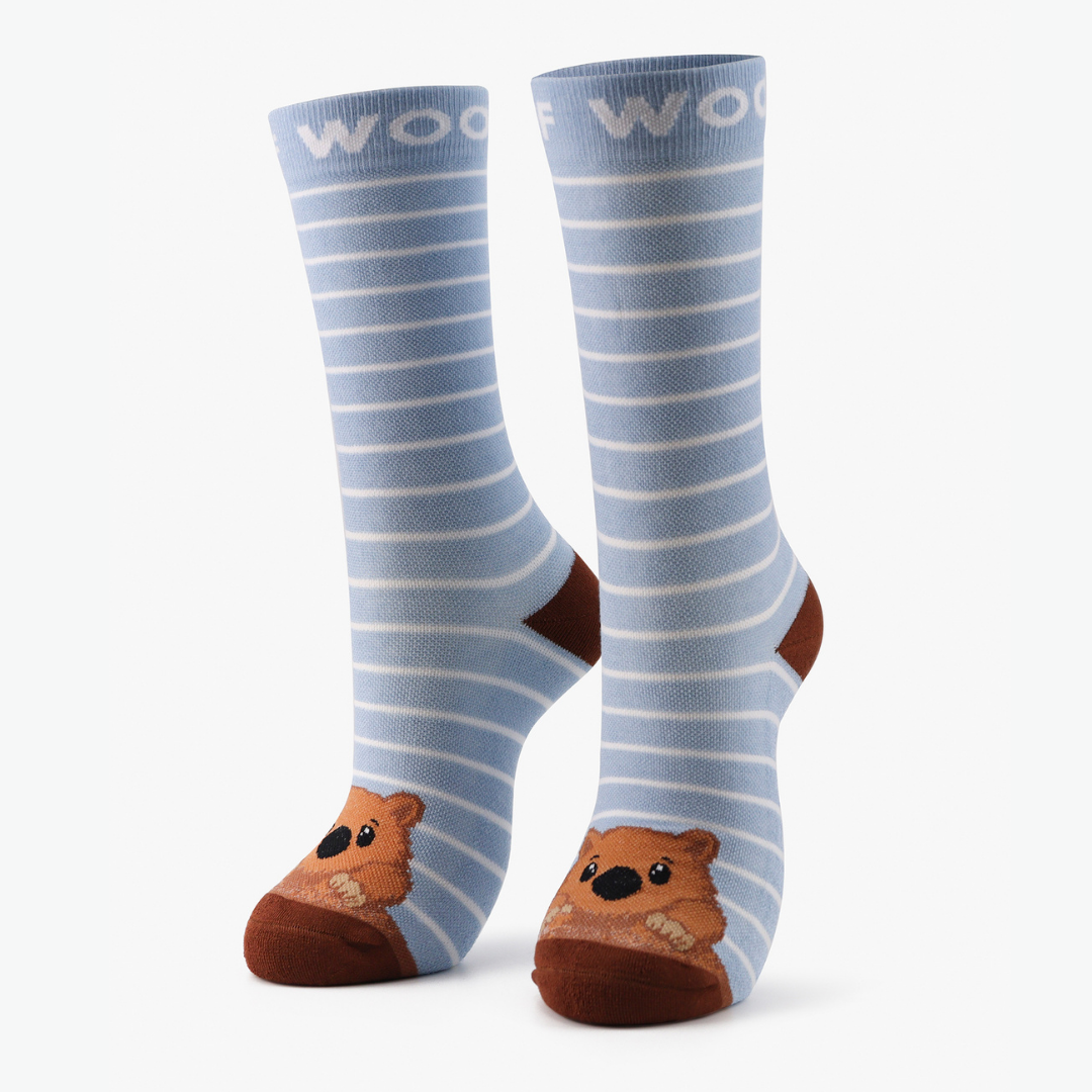 Pair of light blue striped bamboo crew compression socks with wombat design standing against a plain white background.